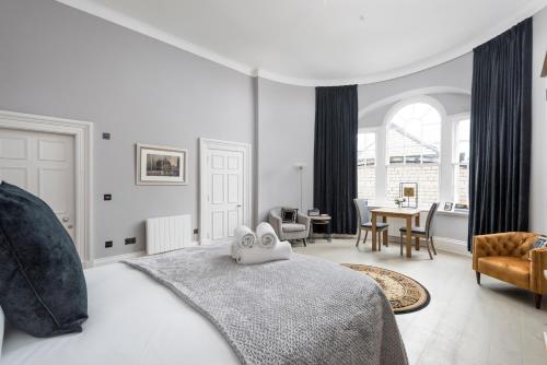 a white bedroom with a bed and a dining room at Modern George Street Studio sleeping 2 in Edinburgh
