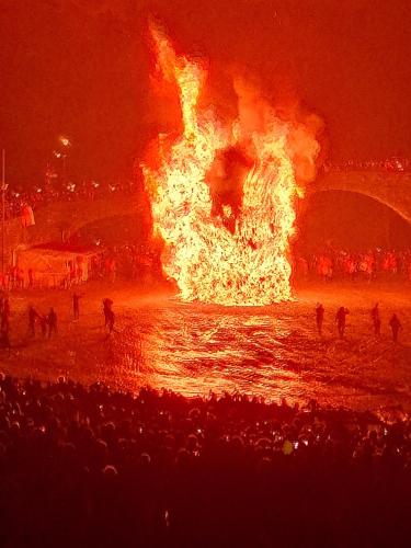 a fire in the water with people standing around it at Az. Agr. IL PARADISO di Beatrice Bondielli in Pontremoli