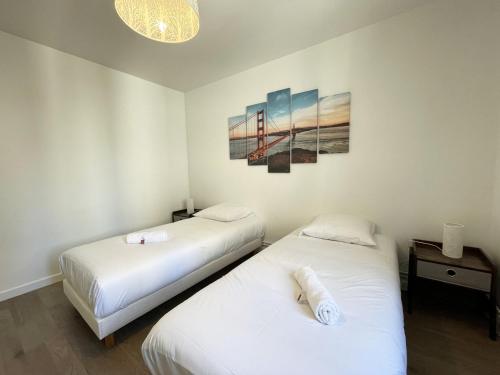 a room with two beds and a painting on the wall at Au bord de l'Eure - Free parking in Chartres