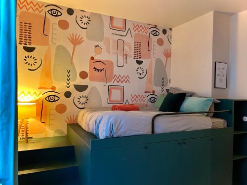 a bedroom with a bed with a wall covered in wallpaper at MaïHomes - La Villa Marseillaise in Marseille