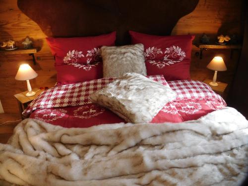 a bed with red and white blankets and pillows at Wellnessoase mit Sauna und Whirlpool in Inzell