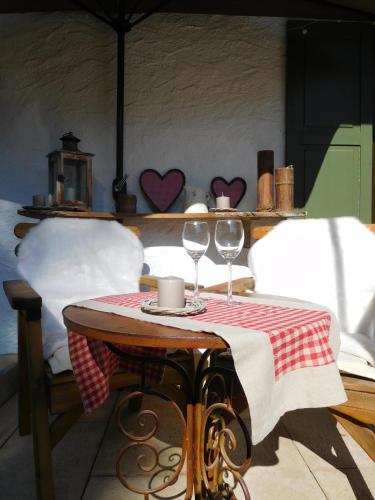 a table with two wine glasses on top of it at Wellnessoase mit Sauna und Whirlpool in Inzell