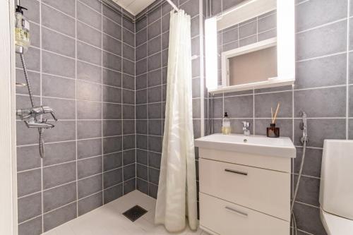 y baño con cortina de ducha y lavamanos. en Strömfors Bed & Bistro Oy, en Strömfors