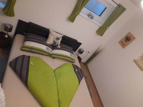 a bedroom with a green bed with a window at Ferienwohnung Bärbel in Sautens