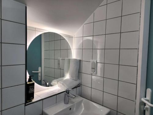 uma casa de banho com um lavatório e um espelho em ibis budget Chambourcy Saint Germain em Chambourcy