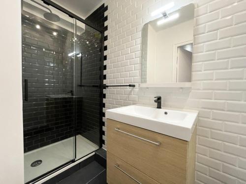 une salle de bain avec un lavabo et une douche dans l'établissement Le Grand Rapporteur, à Chartres