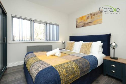 sypialnia z łóżkiem z niebieskim i żółtym kocem w obiekcie 3 Bedroom Tranquil Haven for Contractors and Families by Coraxe Short Stays w mieście Old Hill