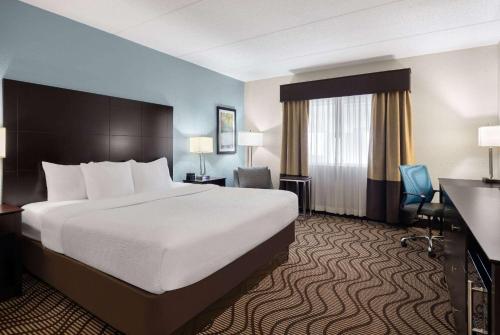 um quarto de hotel com uma cama grande e uma secretária em La Quinta by Wyndham Knoxville Airport em Alcoa