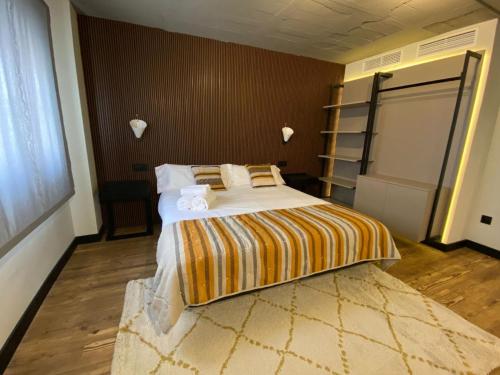 a bedroom with a large bed with a striped blanket at Bubu - Nuevo edificio de apartamentos en el centro in Málaga