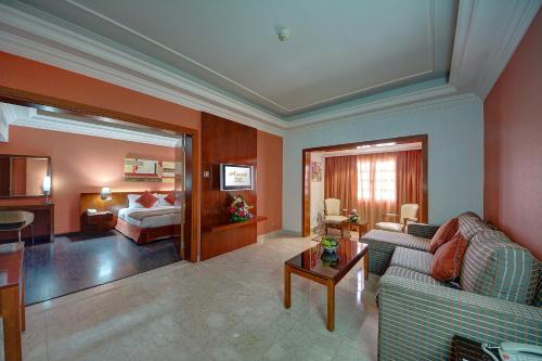 salon z kanapą i łóżkiem w obiekcie Ascot Hotel w Dubaju