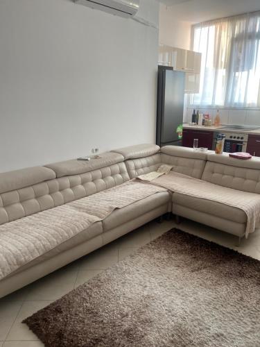 a white couch in a living room with a kitchen at Ylli Shabani in Tirana