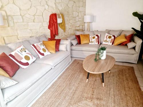 un soggiorno con due divani e un tavolo di NOUVEAU - Maison Cozy 150m2 - 3 chambres - Grand Salon - Clim - Wifi fibre - Netflix - 5' du centre et gare - Cour intérieure - 15' des plages a Montpellier