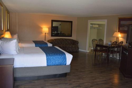 a hotel room with a bed and a couch at Travelodge by Wyndham Trinidad in Trinidad