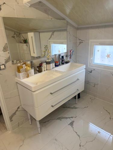 Baño blanco con lavabo y espejo en Villa Natval - 600 m2, en Antibes