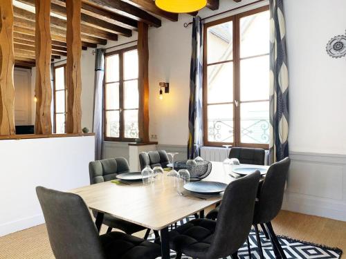 une salle à manger avec une table et des chaises en bois dans l'établissement Le Clocher- Appartement dans le cœur de ville, à Chartres