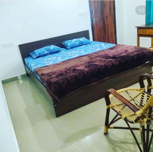 Una cama con sábanas moradas y una silla en una habitación en Edakkal Cottages, en Ambalavayal