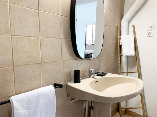 La salle de bains est pourvue d'un lavabo et d'un miroir. dans l'établissement Le Clocher- Appartement dans le cœur de ville, à Chartres