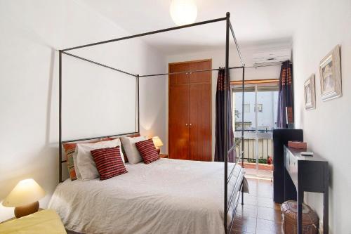 a bedroom with a canopy bed in a room at Apartamento Santos in Tavira