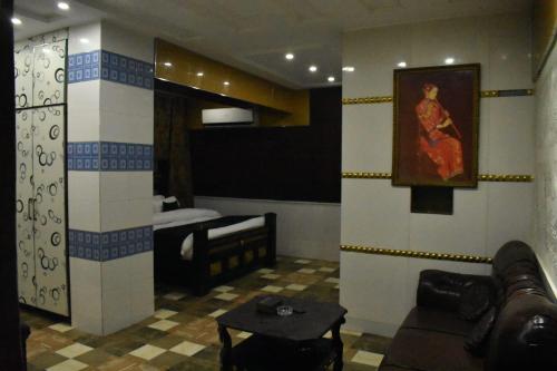 Grand AlFateh Hotel في لاهور: غرفة معيشة مع أريكة وسرير