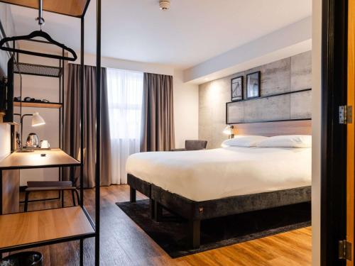 una camera d'albergo con un grande letto e una scrivania di ibis Coleraine Riverside a Coleraine
