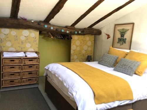 Un dormitorio con una cama grande con una manta amarilla. en Les Granges Lestang, en Sainte-Innocence