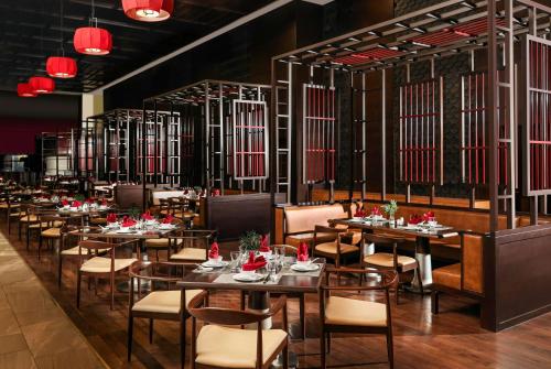 a dining room with tables and chairs and red lights at Wyndham Grand Phu Quoc in Phú Quốc