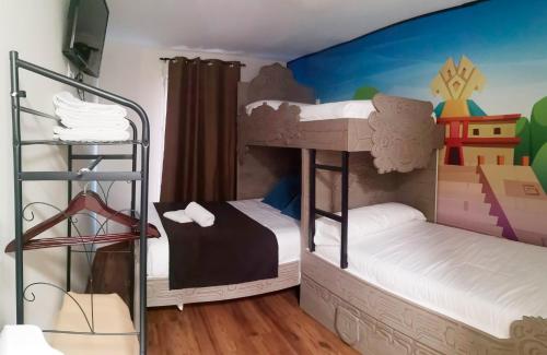 2 Etagenbetten in einem Zimmer mit Wandbild in der Unterkunft El Indio CHocolatería Boutique Hostel in Pinto