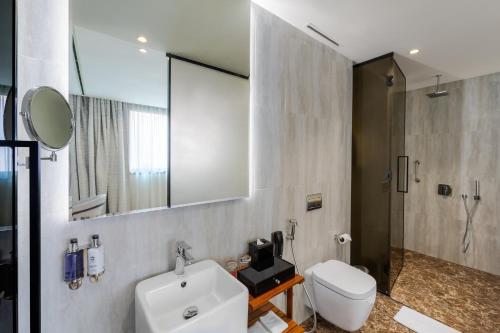 a bathroom with a sink and a toilet and a mirror at voco Dubai Monaco, the Heart of Europe by IHG in Dubai