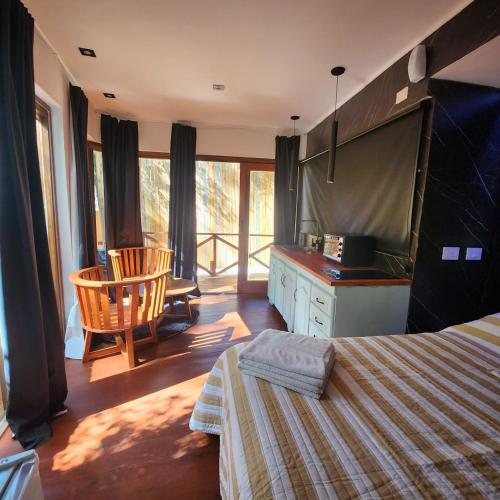 1 dormitorio con 1 cama y cocina con balcón en Jack y Rouse suites de mar en Mar de las Pampas