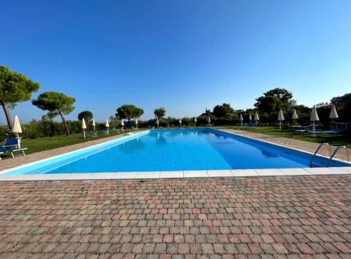 格拉多的住宿－Calilla Home - appartamento Maestrale，一座大型蓝色游泳池,铺有砖地板