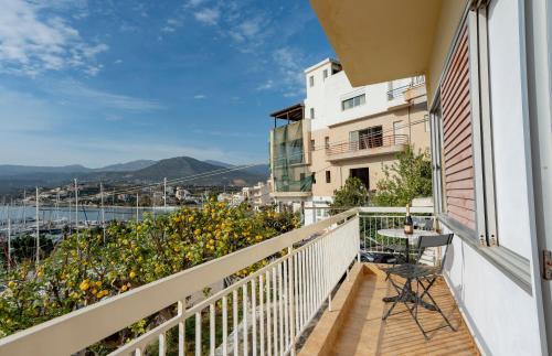 a balcony with a table and chairs on a building at Jelena Apartments By The Sea in Agios Nikolaos