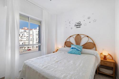 um quarto branco com uma cama e uma janela em Apartamento 1a linea Valdelagrana em El Puerto de Santa María