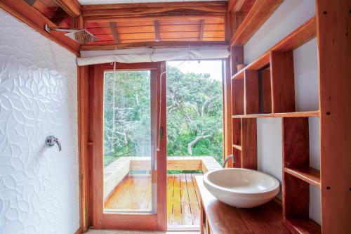 a bathroom with a sink and a large window at Aloha 15 in Ponta Mamoli