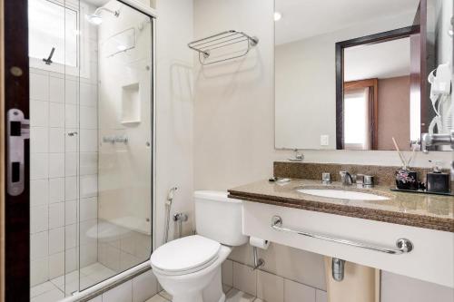 La salle de bains est pourvue de toilettes, d'une douche et d'un lavabo. dans l'établissement Suítes Inside Windham Sao Paulo Paulista, à São Paulo