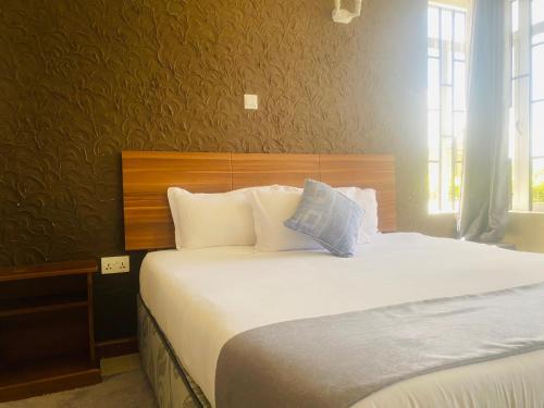 1 dormitorio con 1 cama grande con almohadas blancas en Pendeza La Casa, en Naivasha