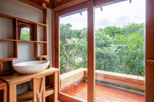 a bathroom with a sink and a large window at Aloha 15 in Ponta Mamoli