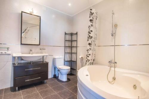 een badkamer met een bad, een wastafel en een toilet bij Villa Ebro - PlusHolidays in Calpe