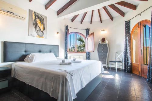 1 dormitorio con 1 cama grande en una habitación con ventanas en Villa Ebro - PlusHolidays, en Calpe