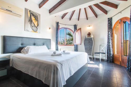 a bedroom with a large bed in a room with windows at Villa Ebro - PlusHolidays in Ifach