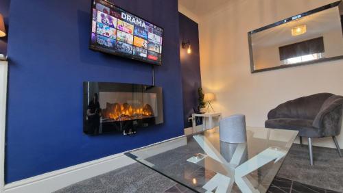 a living room with a fireplace and a tv at Cosy home perfect for families and contractors in Darlington