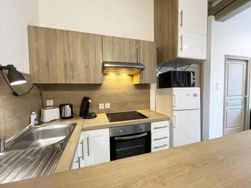 une cuisine avec un évier et une cuisinière four supérieur dans l'établissement Le Versant de la Cathédrale - Parking - Autonomous, à Chartres