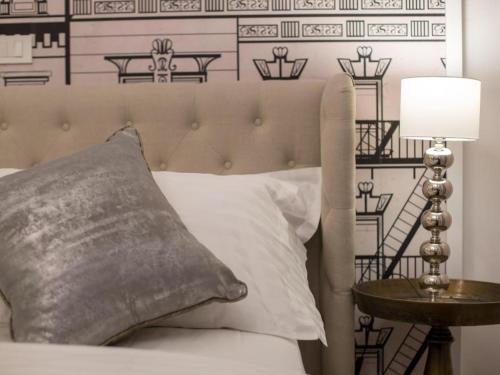 a bed with a pillow and a side table with a lamp at Tailor Apartment with a Private Terrace in Dubrovnik