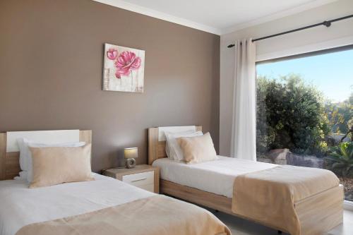 two beds in a bedroom with a window at Villa Colina in Salir de Matos
