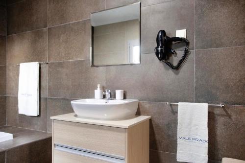 uma casa de banho com um lavatório e um espelho em Villa Colina em Salir de Matos