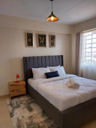 Un dormitorio con una cama grande y una ventana en Rawin Homes, en Nyeri