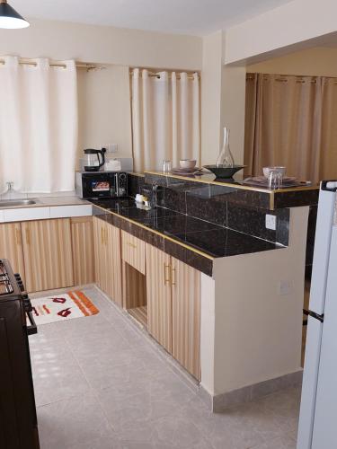 a kitchen with a black counter top in a room at Rawin Homes in Nyeri