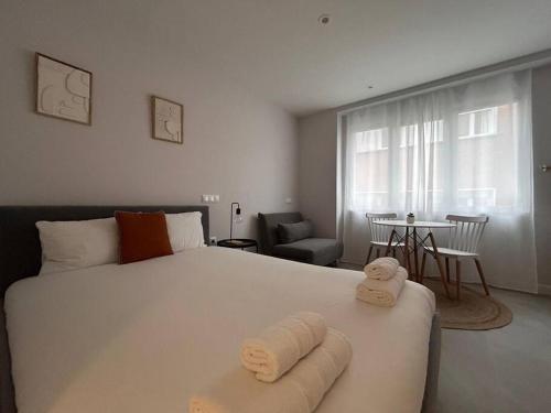 ein Schlafzimmer mit einem großen weißen Bett mit Handtüchern darauf in der Unterkunft Cozy studio in Tetuan - En 1/7 in Madrid