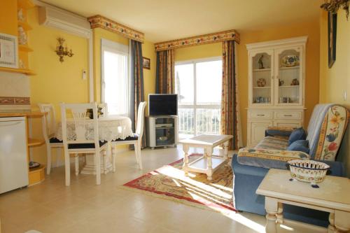 a living room with a blue couch and a tv at Minerva Jupiter Apartments in Benalmádena