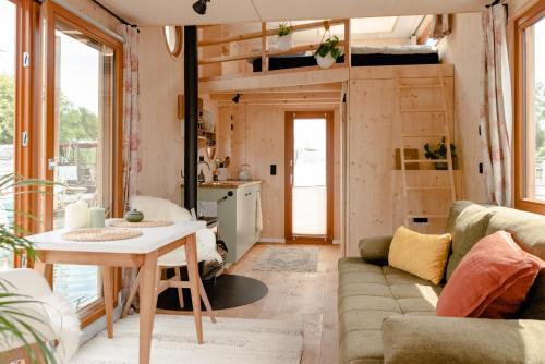 a living room with a couch and a table at Tiny-Hausboot mit Kamin und Dachterrassenlounge in Hamburg