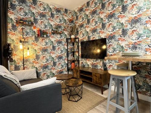 a living room with a couch and floral wallpaper at Le Floral - Parking - Self check in in Chartres